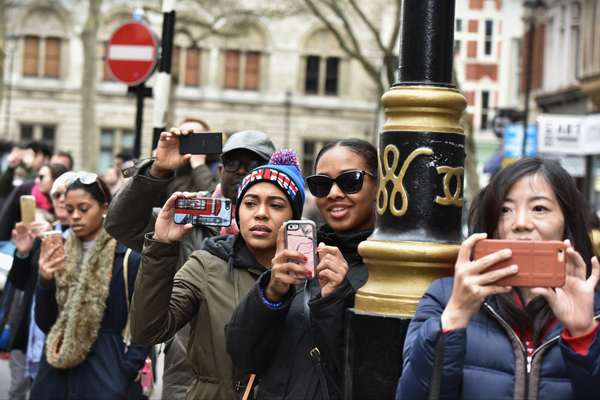 Bystanders filming a scene with their smartphones