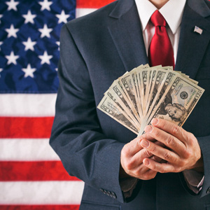 Man holding money in front of US flag.