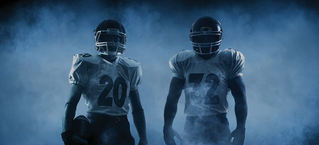 Two football players in shadow and mist