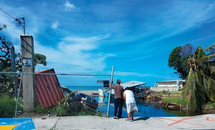 Couple looking at the remains of their home