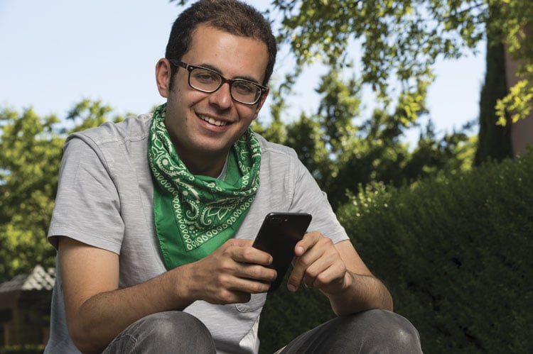guy in glasses with a cell phone wearing a bandana