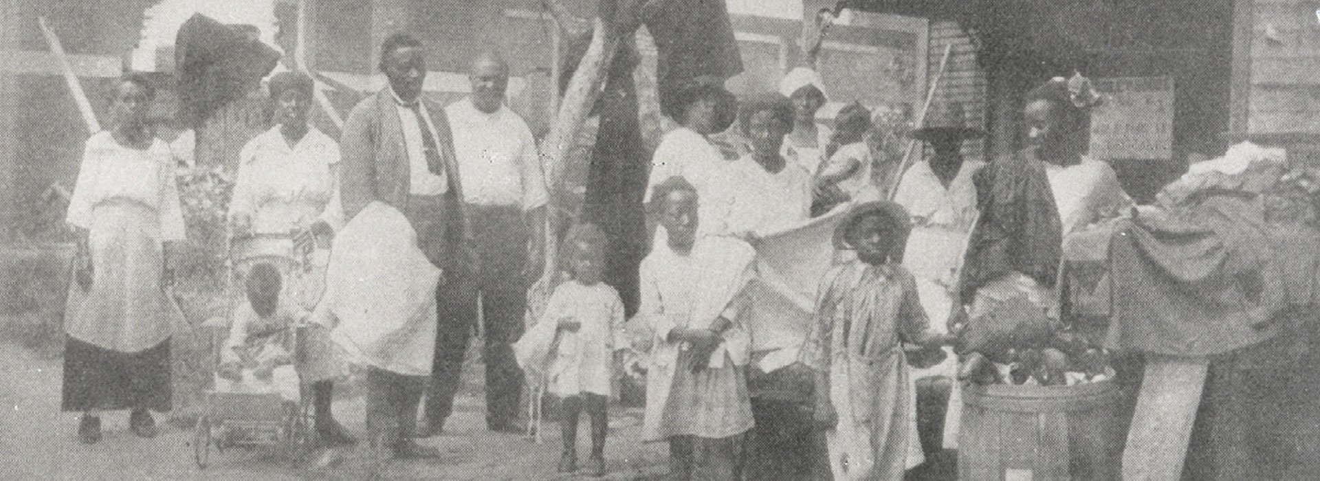 The Rev. Robert A. Whitaker, whose Mt. Zion Baptist Church was burned to the ground, distributes relief goods with his family to refugees after the massacre.