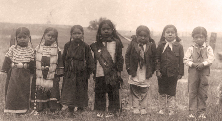 Sioux children appear in their traditional clothing before entering boarding school.