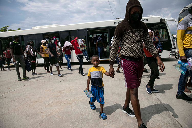 Deported Haitians file off a bus