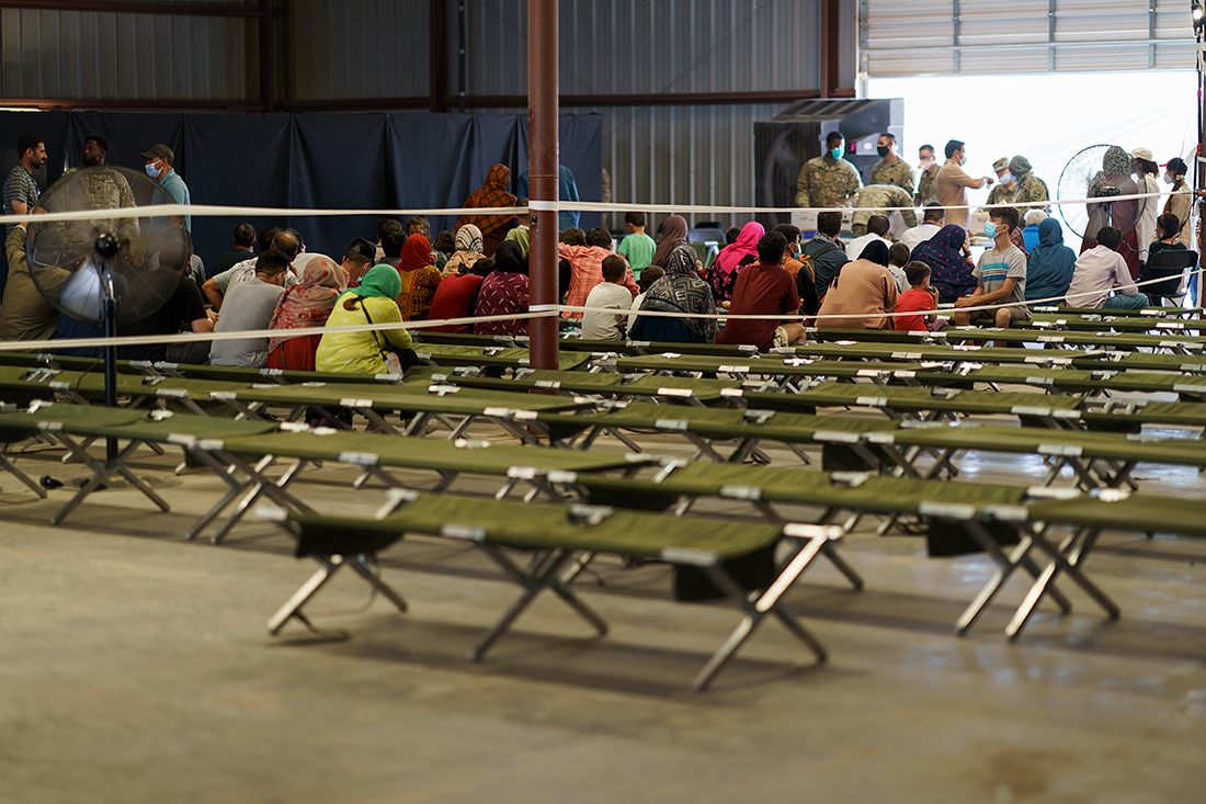 People wait in folding chairs at a military base
