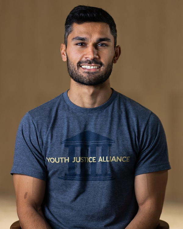 Armin wearing a t-shirt with the Youth Justice Alliance logo