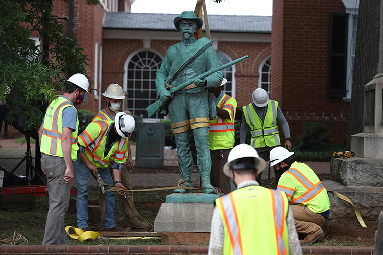 Confederate statue being removed from a courthouse grounds by construction workers
