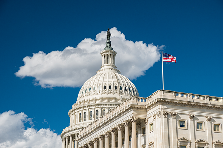 ساختمان کنگره ایالات متحده در یک روز آفتابی با اهتزاز پرچم آمریکا