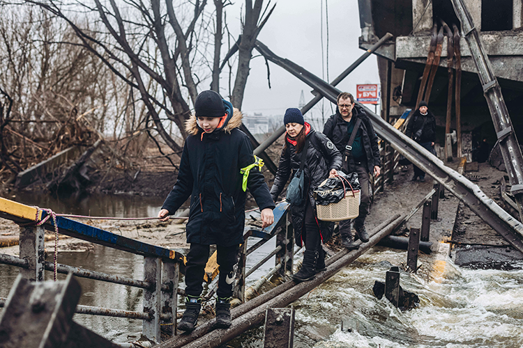 Civilians crossing a collapsed bridge