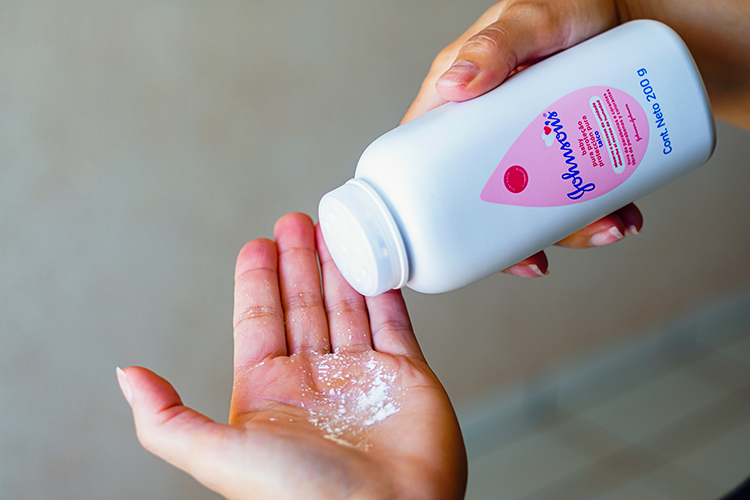Baby powder from Johnson and Johnson being shaken into a person's hand
