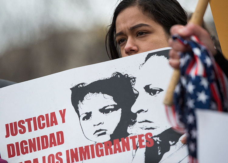 Girl holding sign advocating for immigration protection
