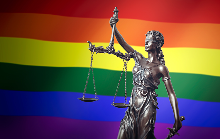Lady Justice standing in front of a rainbow flag