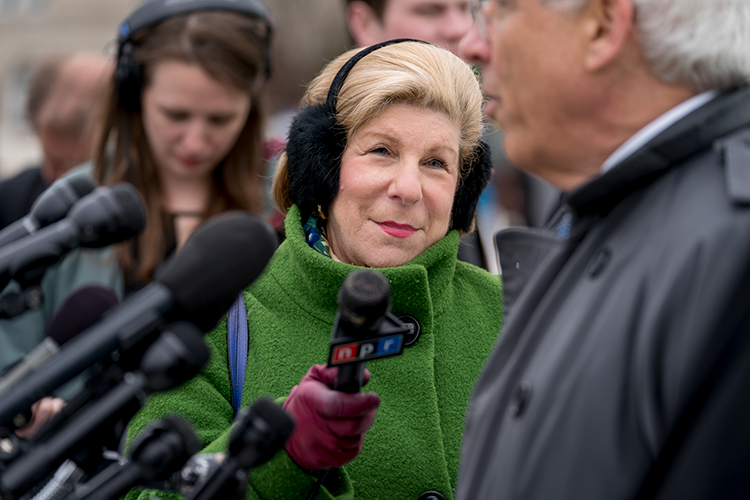 Nina Totenberg on the steps of the Supreme Court Building with an NPR microphone