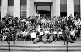 Men and women sitting on steps at law school building.