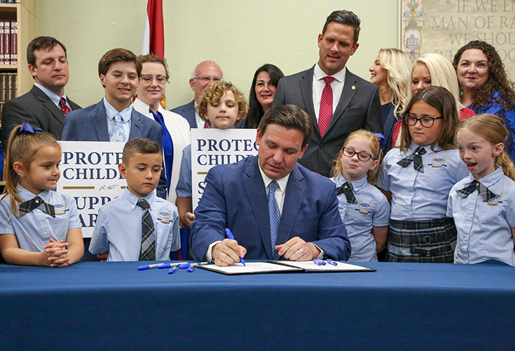 Gov. Ron DeSantis signs bill surrounded by private school children