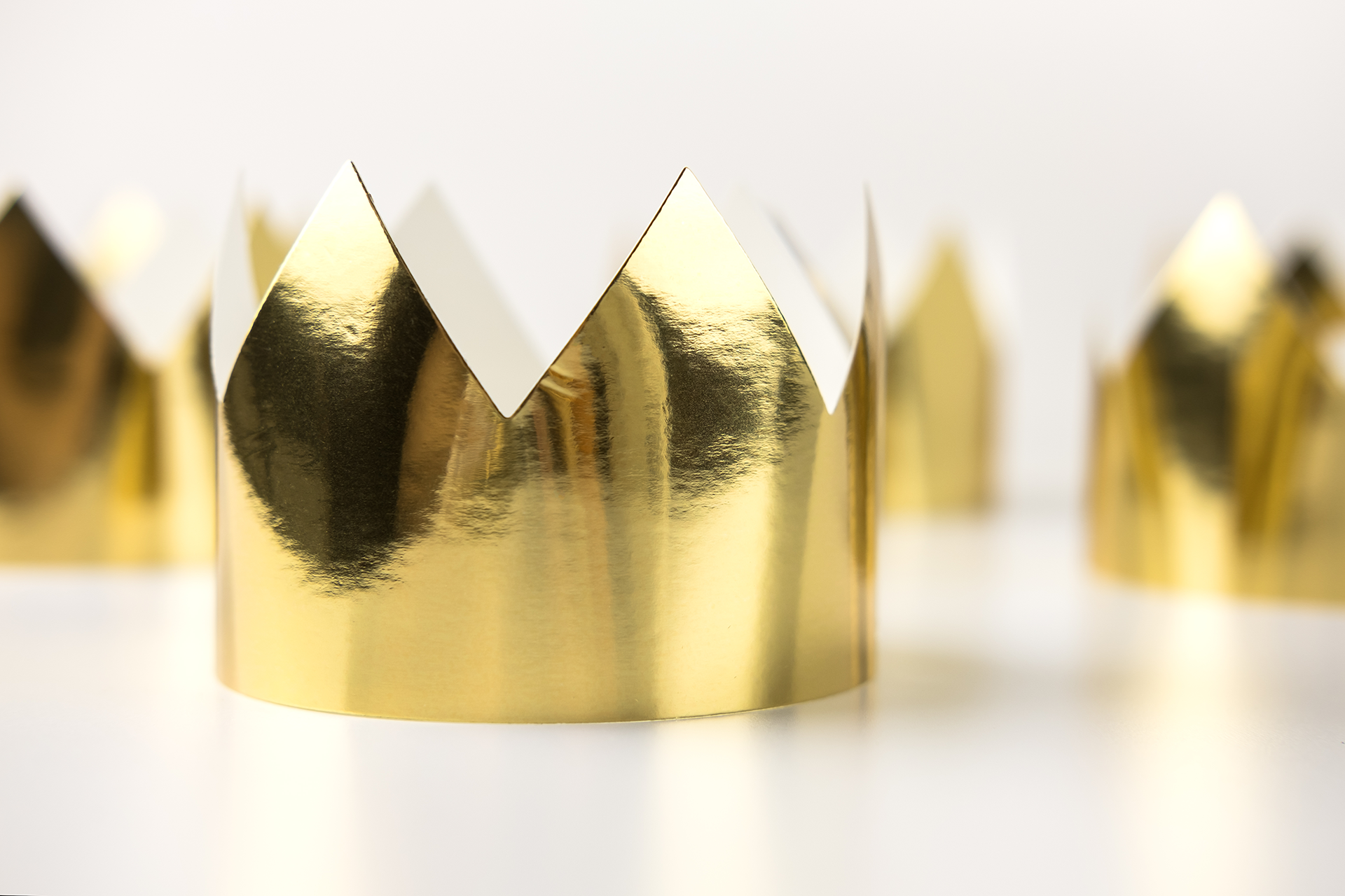 A row of shining golden paper crowns