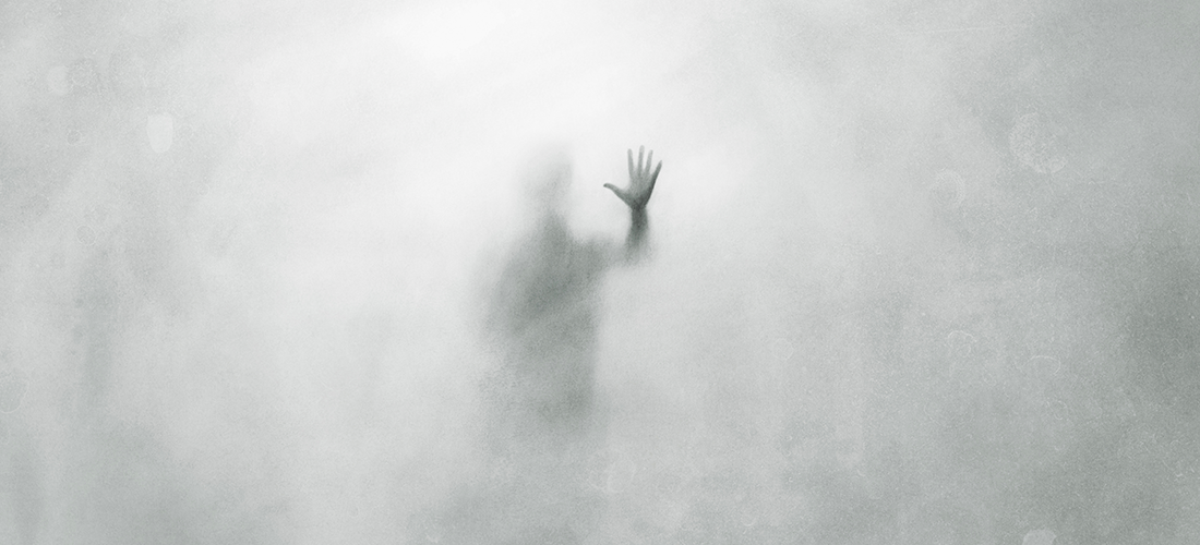 A man obscured by fog, reaching out his hand