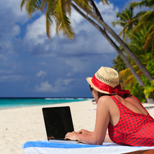 Woman on a beach with her laptop