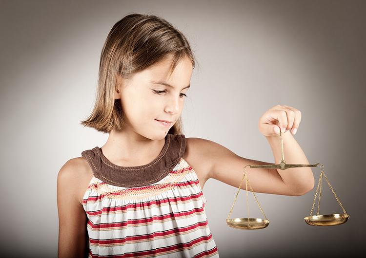 little girl holding the scales of justice