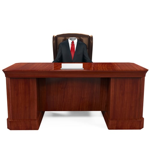 An empty suit behind a desk.