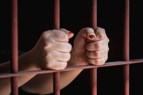 woman's hands in jail