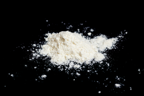 Cocaine drug powder pile on black background